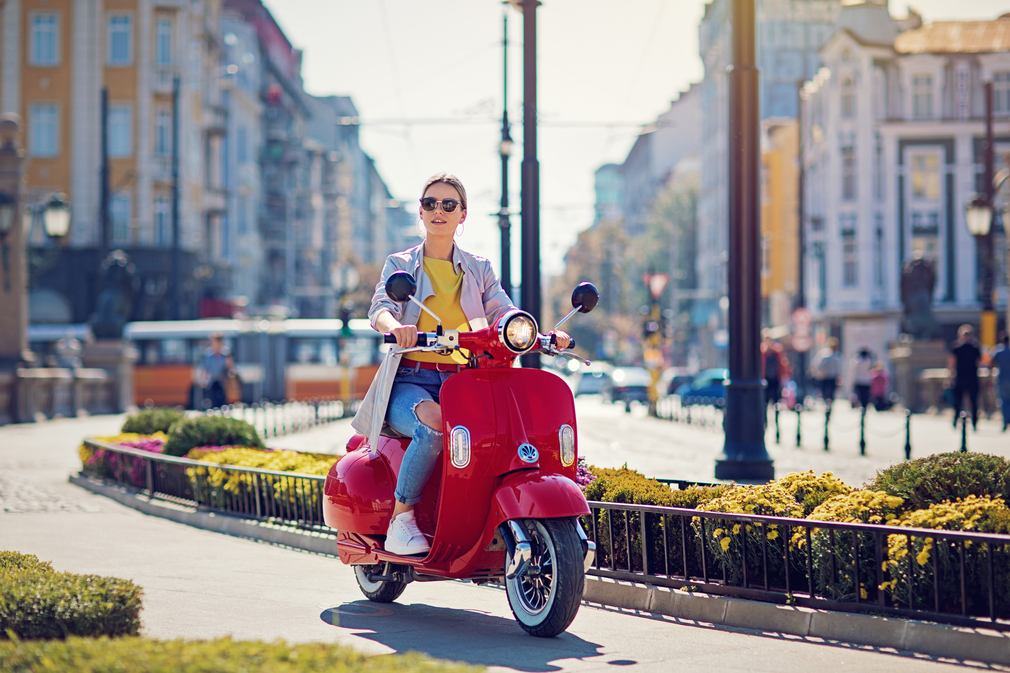 Young girl is riding her scooter in the city
